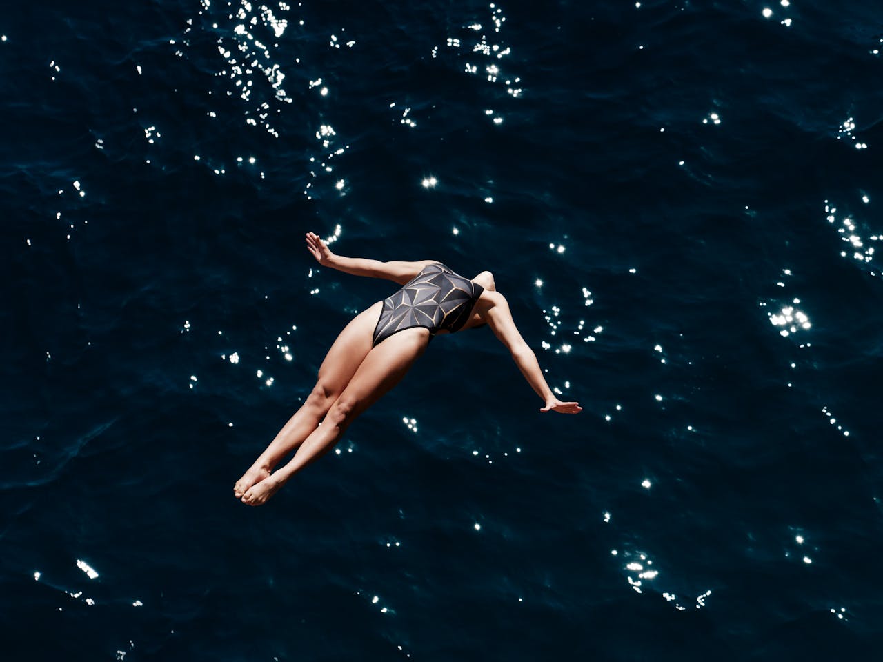 Person diving into deep ocean waters